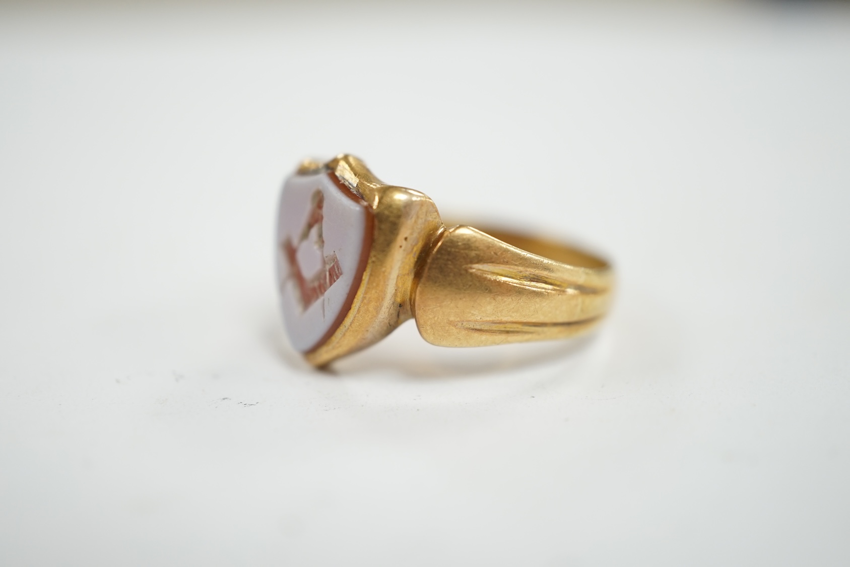 A late Victorian 18ct gold and sardonyx set shield shaped Masonic signet ring, size Q/R, gross weight 5 grams. Condition - fair